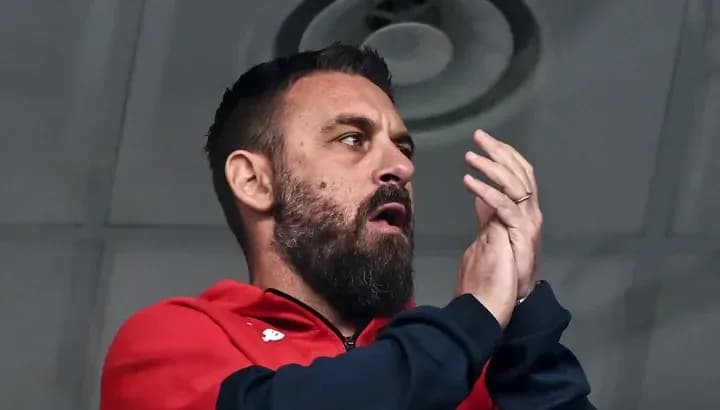 Man clapping in red jacket during event