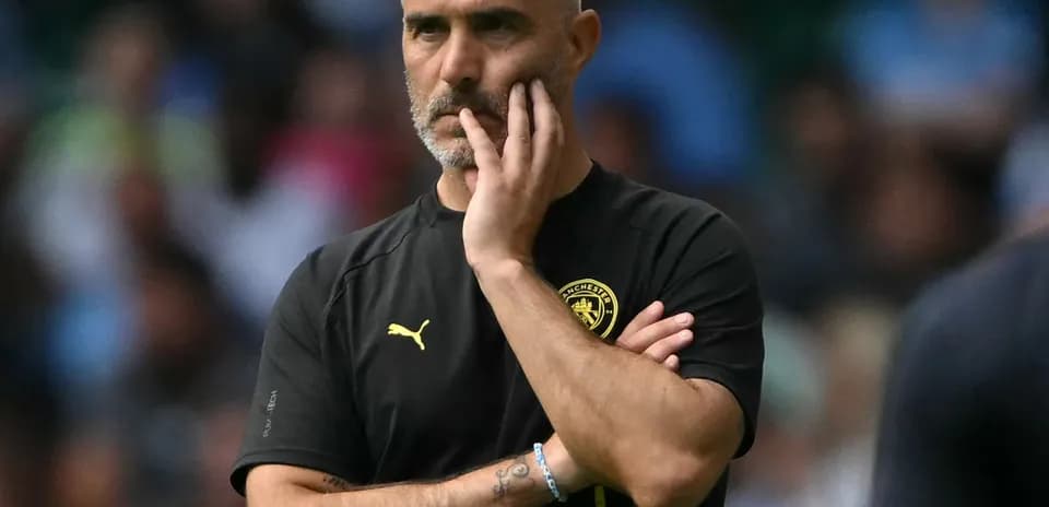 Manager observing the game with a thoughtful expression