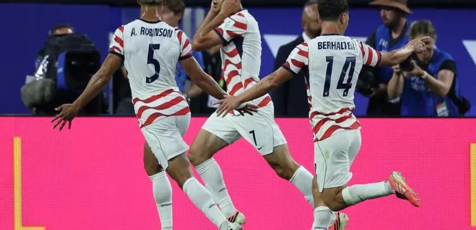 Three USA players celebrating a goal during match