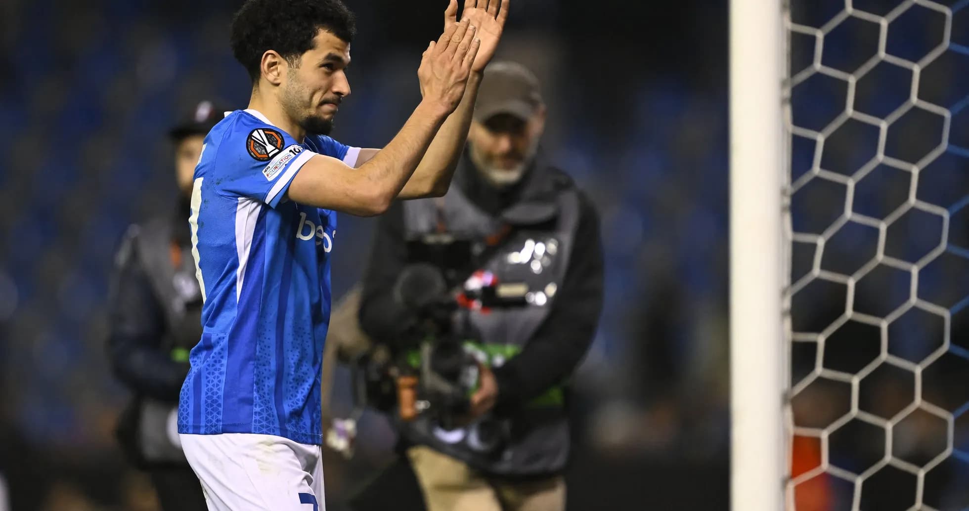 Player applauding fans near goalpost after match