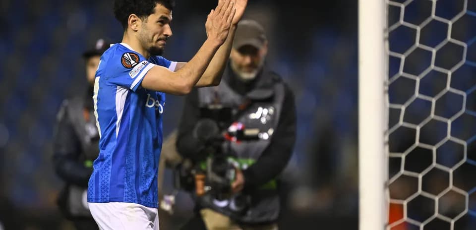 Player applauding fans near goalpost after match