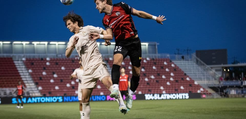 Players competing for the ball in USL match