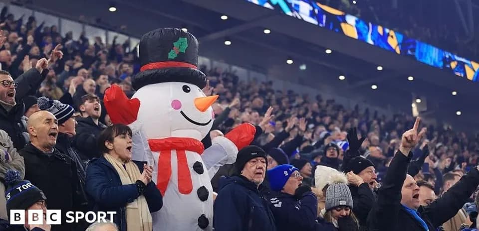 Fans cheering with inflatable snowman at stadium