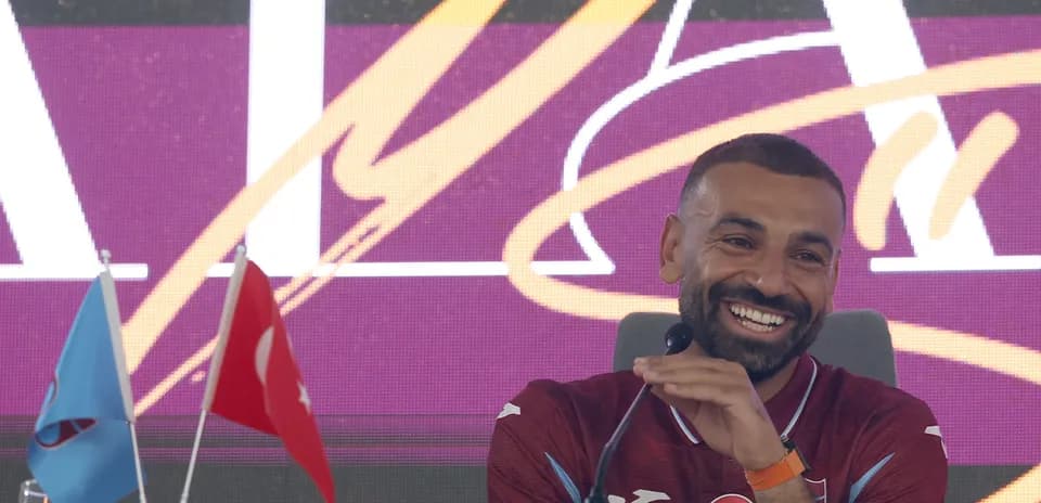 Player at press conference with flags in background