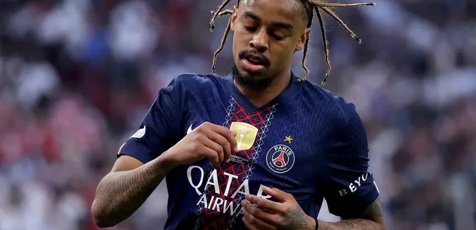 Player inspecting medal on PSG jersey after match