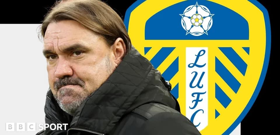 Manager standing in front of Leeds United logo