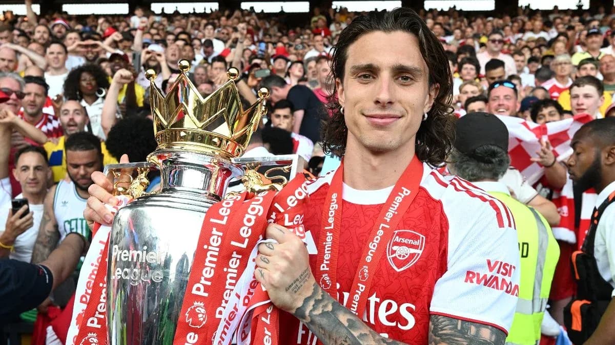 Player celebrating with Premier League trophy and fans