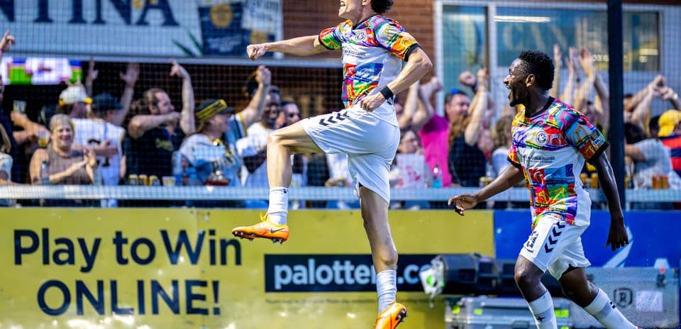 Player celebrating goal with fans in background