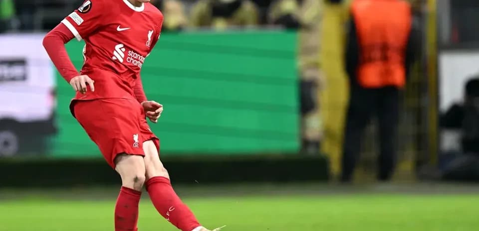 Player kicking ball during match in red kit