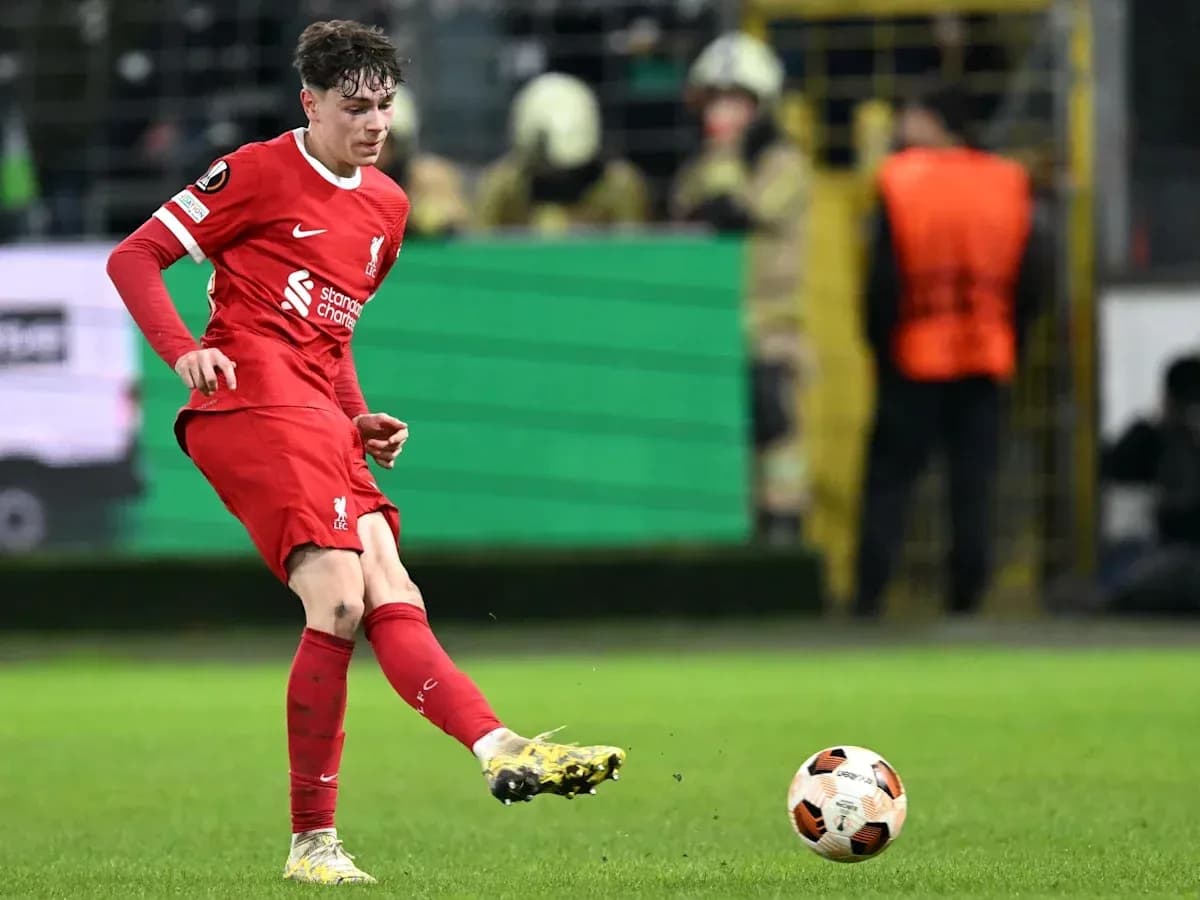 Player kicking ball during match in red kit