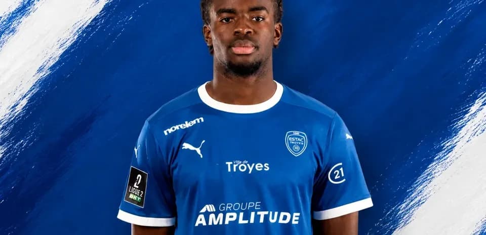 Player posing in ESTAC Troyes blue jersey