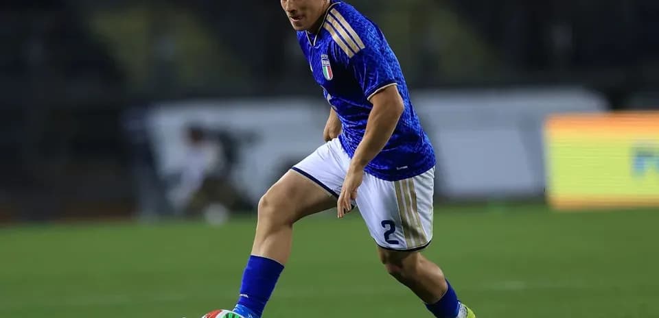 Player in blue jersey dribbling ball on field