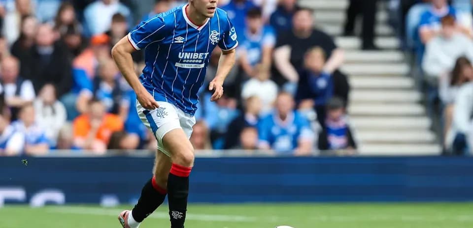 Player in blue jersey running towards soccer ball