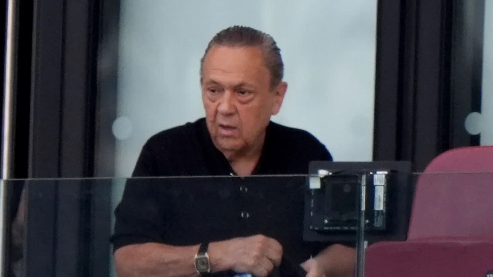 Man in a black shirt at a sports venue