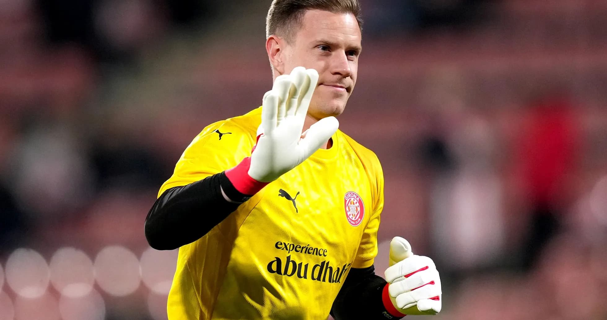 Goalkeeper waving in yellow jersey and gloves