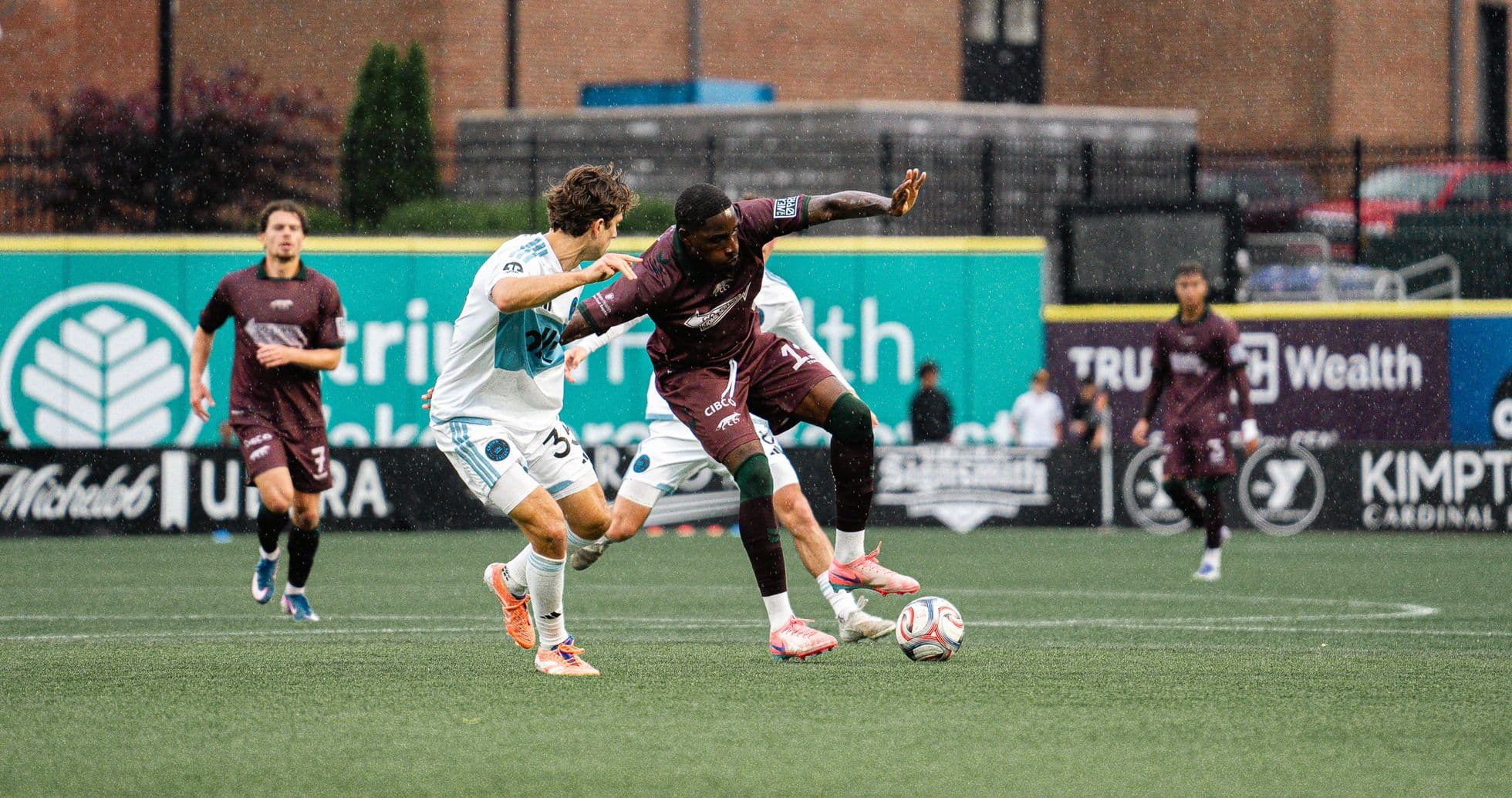 Players competing for the ball in rain