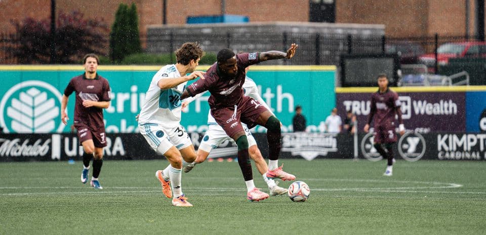 Players competing for the ball in rain