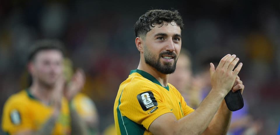 Player in yellow jersey applauding fans after match