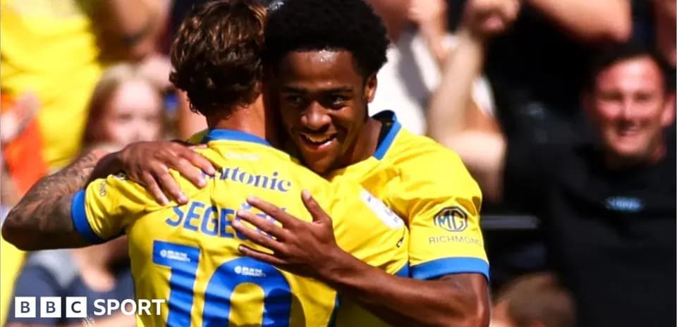 Two players celebrating a goal with a hug