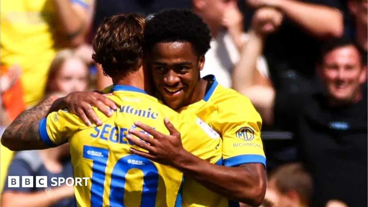 Two players celebrating a goal with a hug