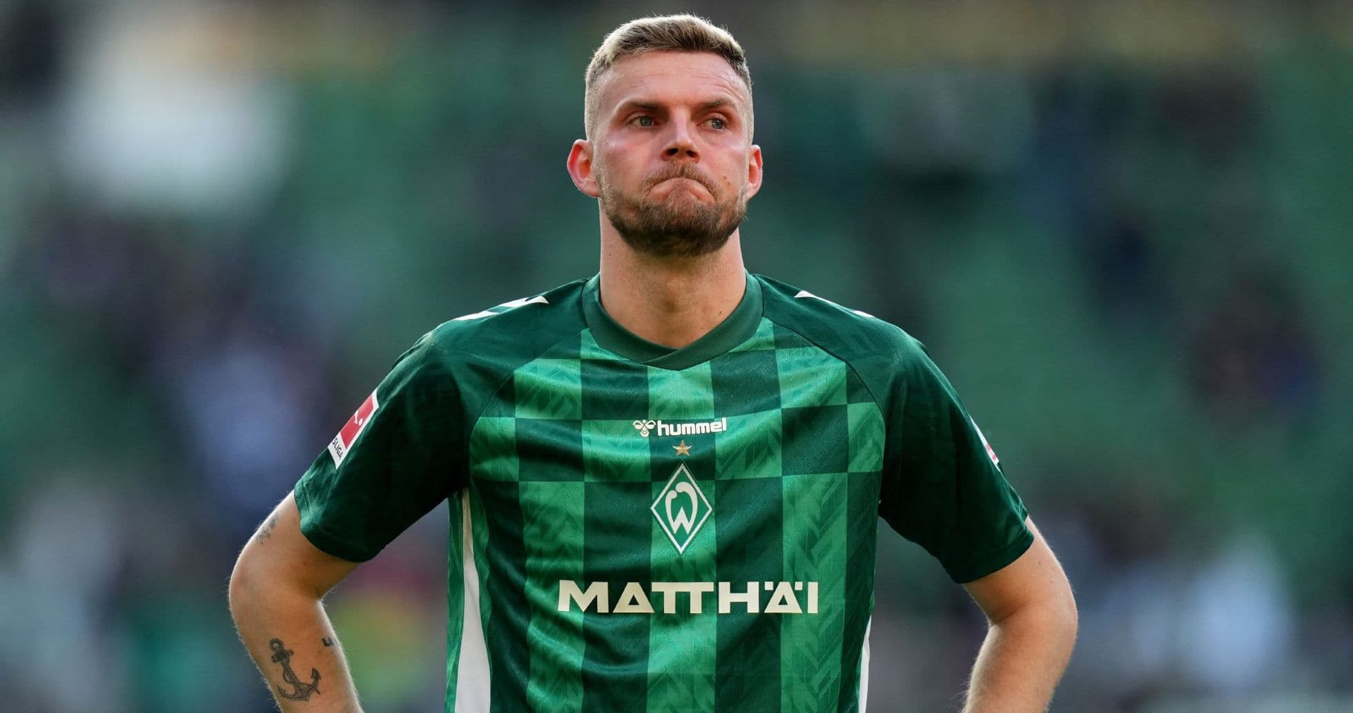Player in green jersey standing on the field