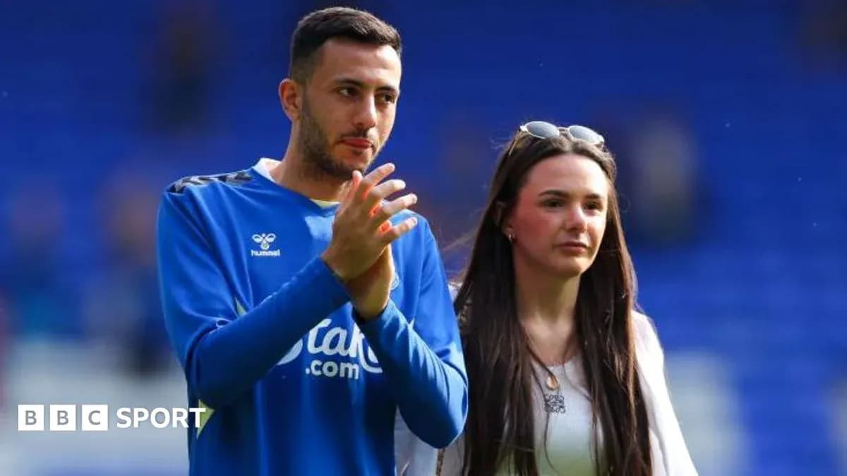 Player applauding with companion on the pitch