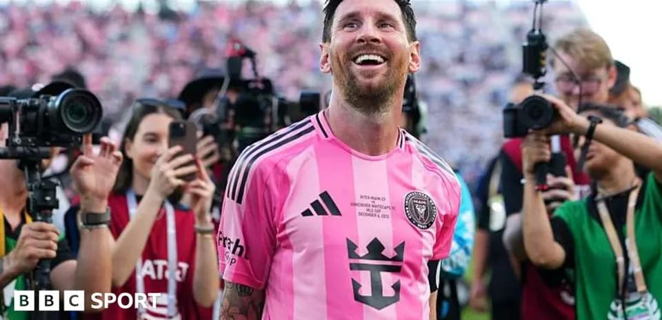 Lionel Messi smiling surrounded by photographers