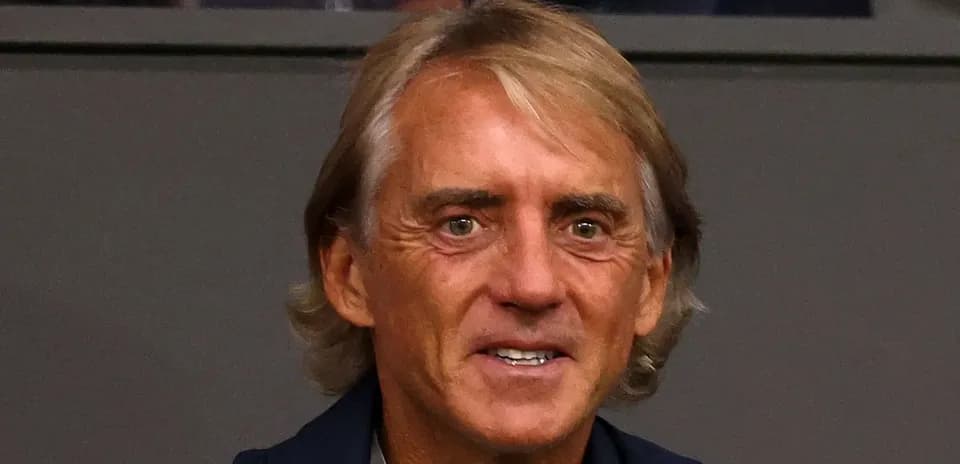 Coach smiling while seated in audience