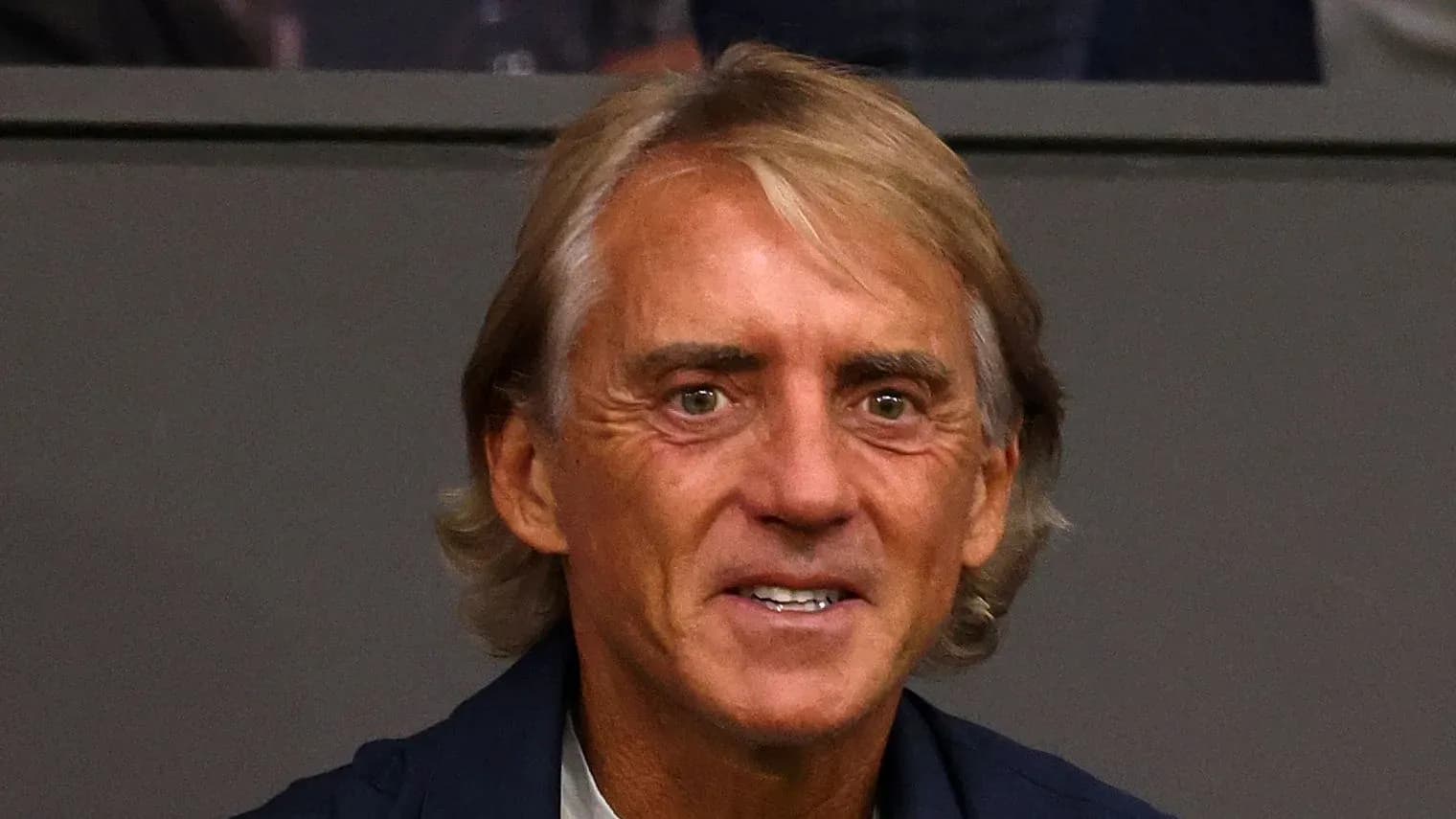 Coach smiling while seated in audience