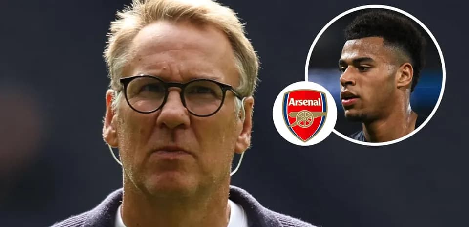 Coach with glasses and Arsenal logo in background