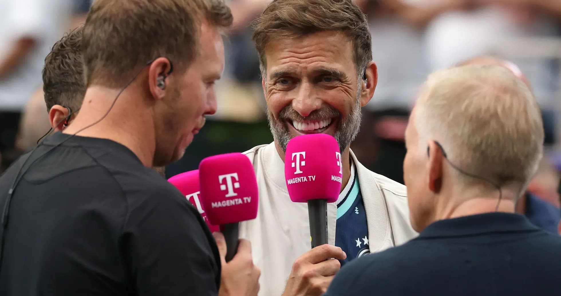 Four people holding microphones during an interview