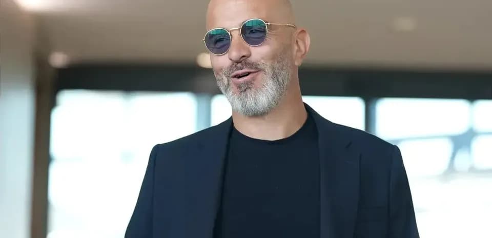 Man with glasses smiling indoors