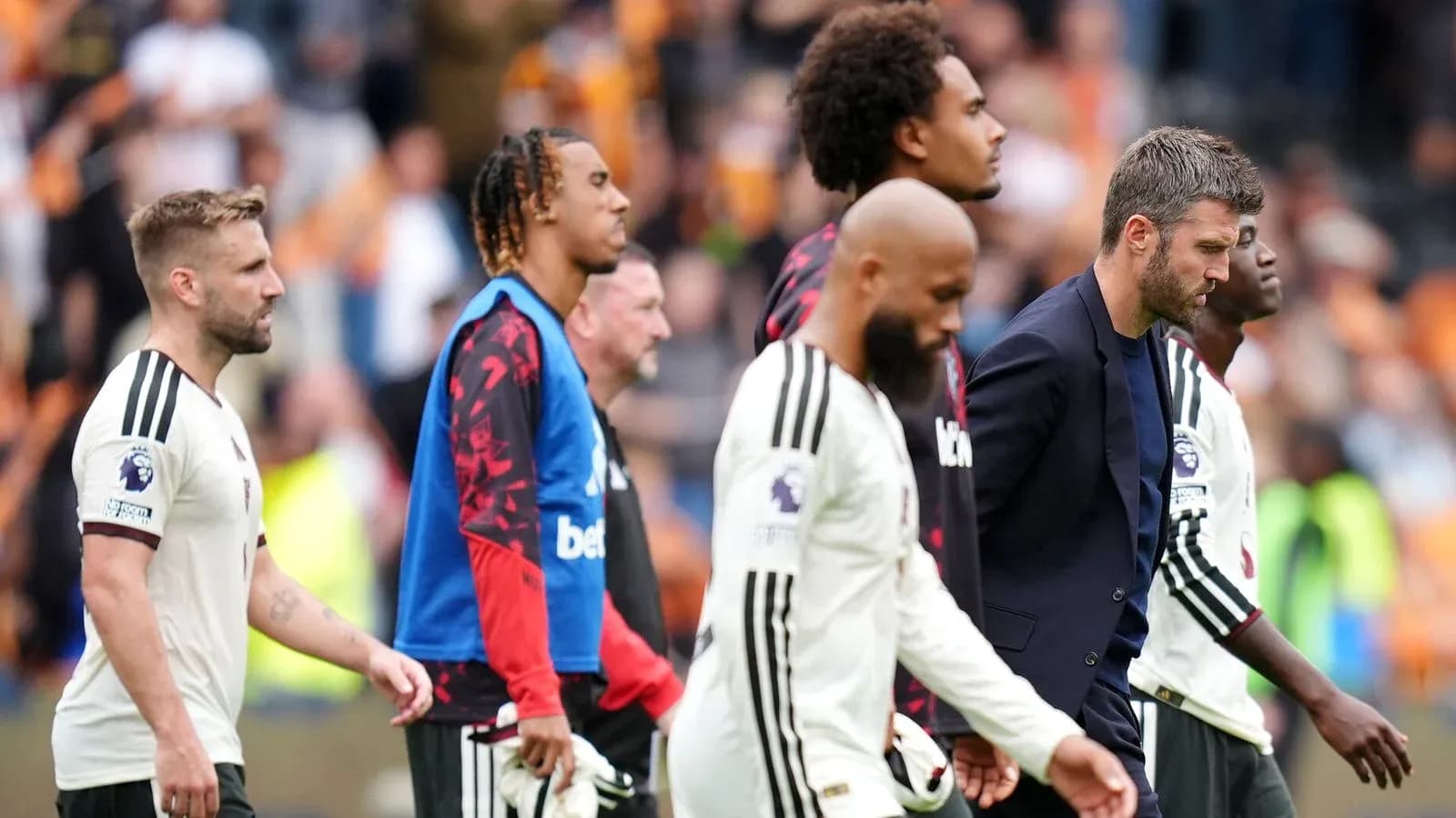 Players and staff walking off the pitch after match