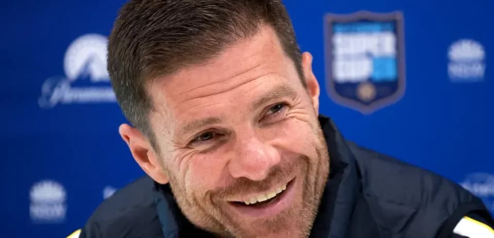 Coach smiling during press conference at podium