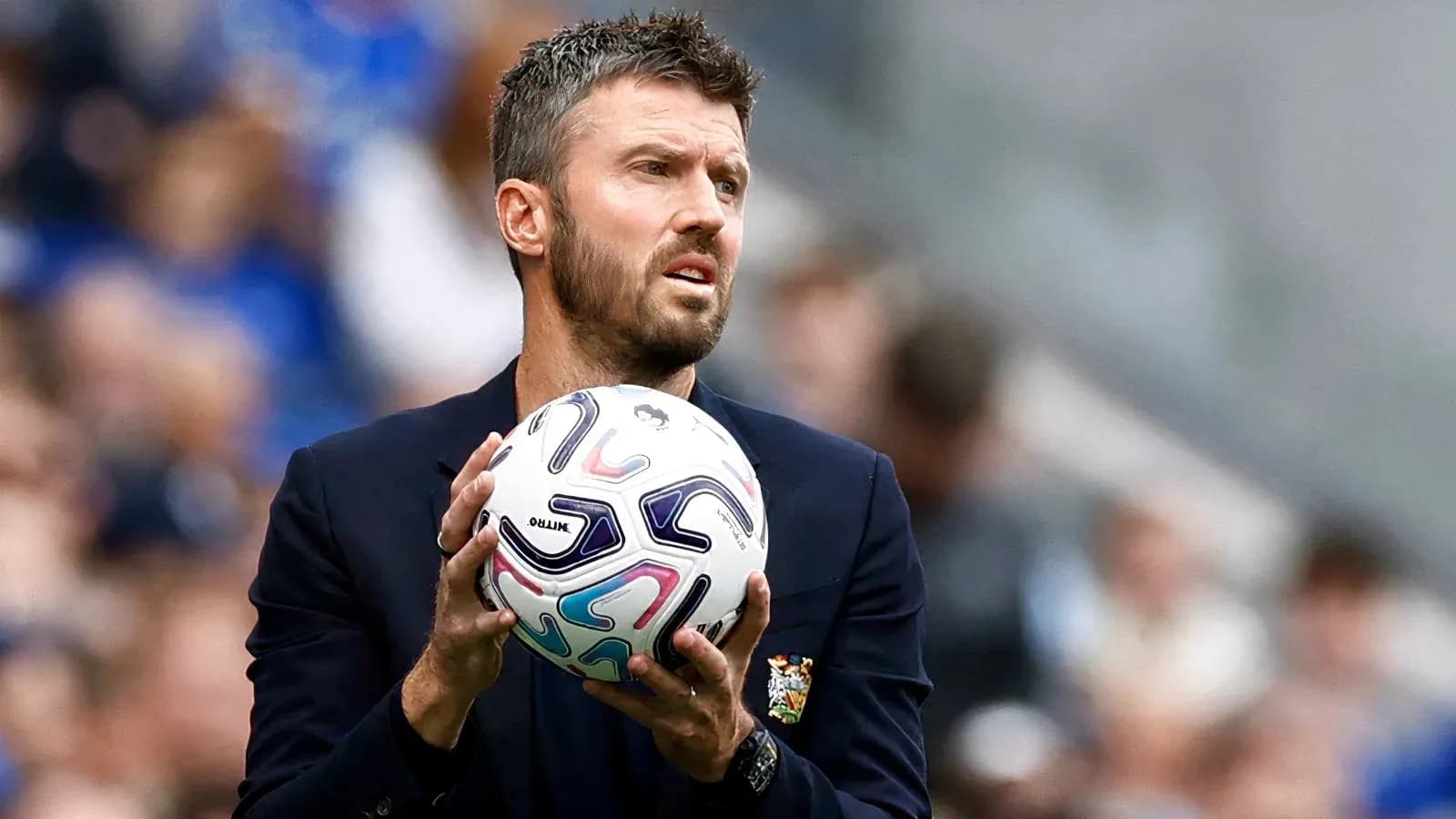 Coach holding ball during match on sidelines