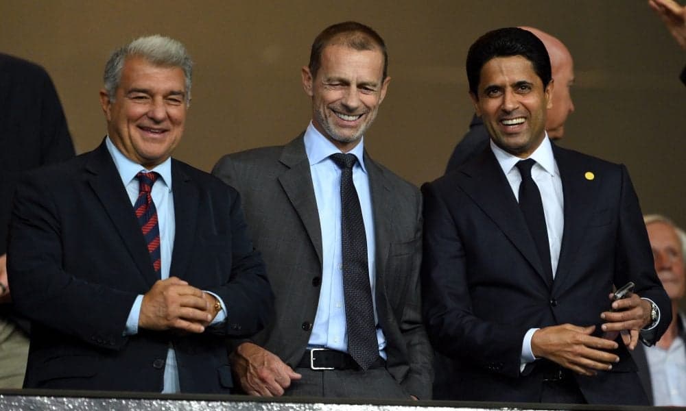 Three football executives smiling in a stadium box