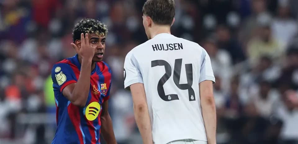 Barcelona player gesturing towards Real Madrid opponent