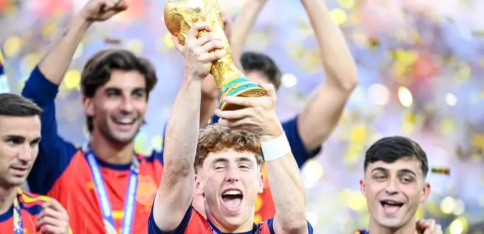 Player celebrating with FIFA World Cup trophy and teammates