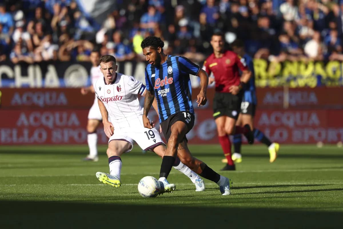 Atalanta player dribbling past Bologna defender