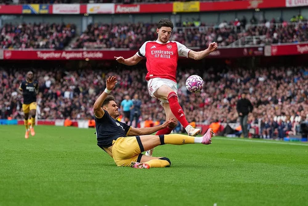 Arsenal player challenging West Ham opponent
