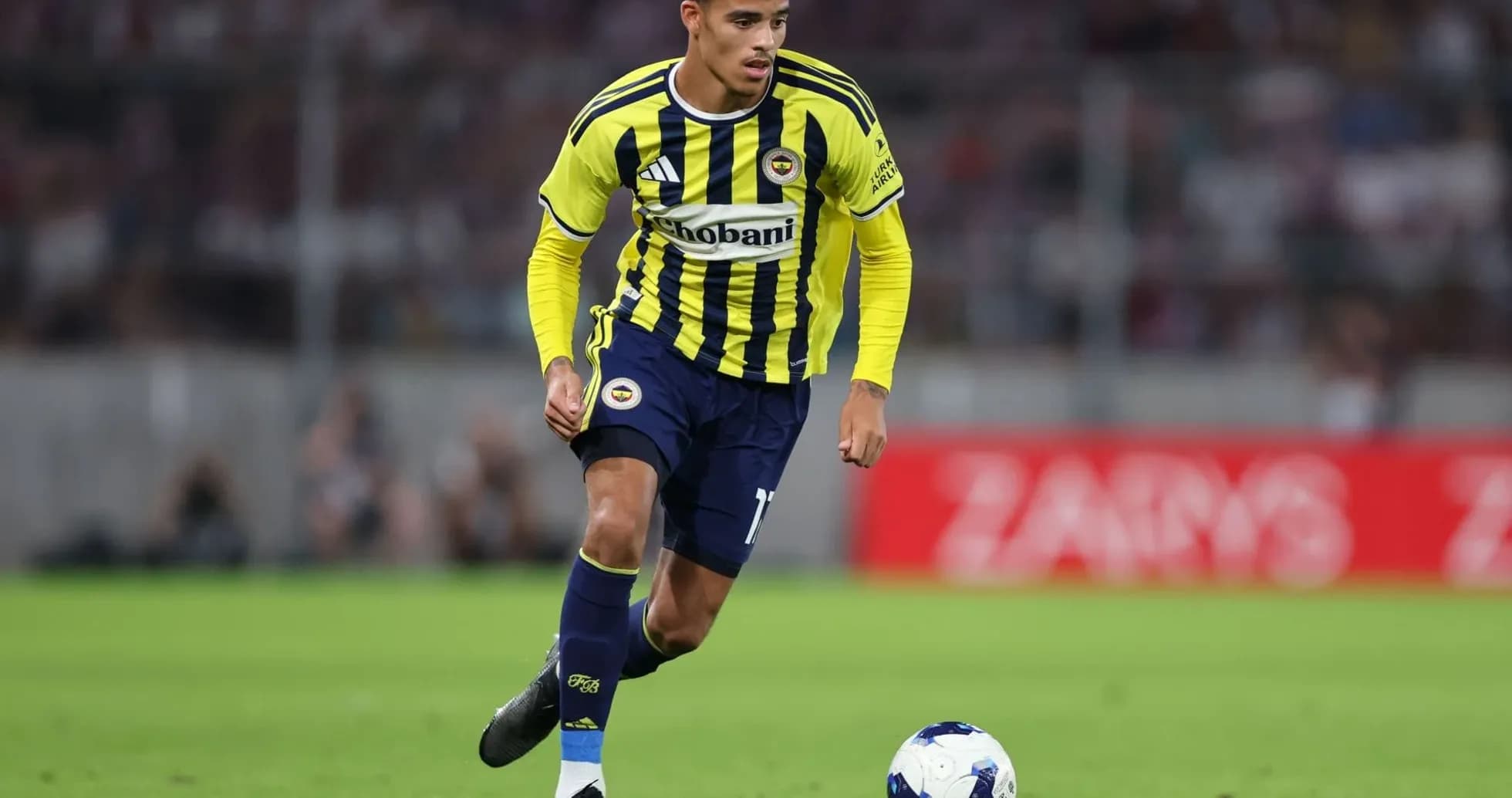 Fenerbahçe player dribbling the ball on pitch
