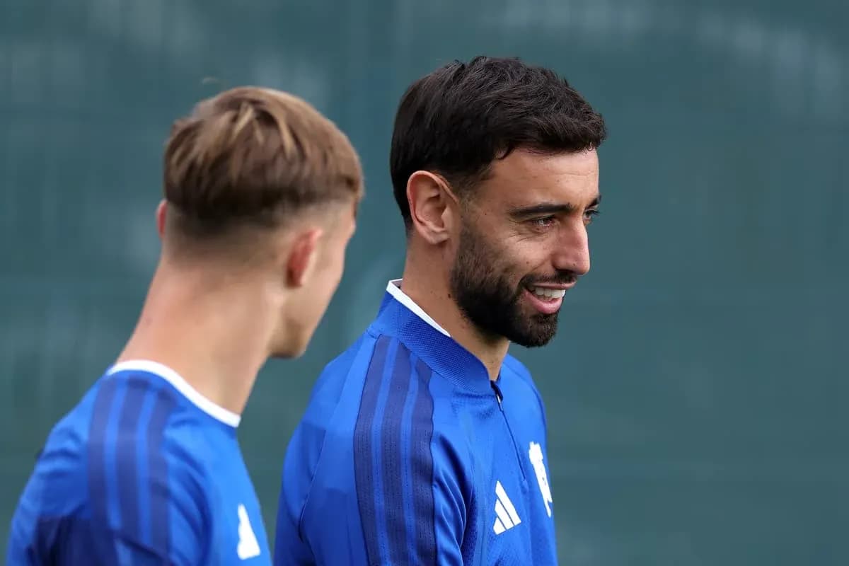 Two football players in blue training kits talking