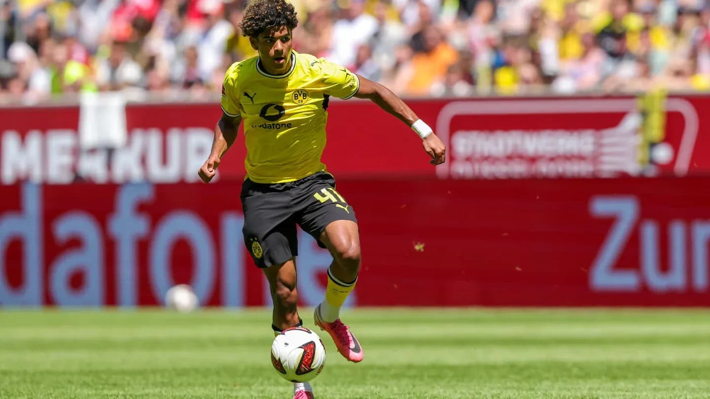 Player in yellow kit dribbling the ball on pitch
