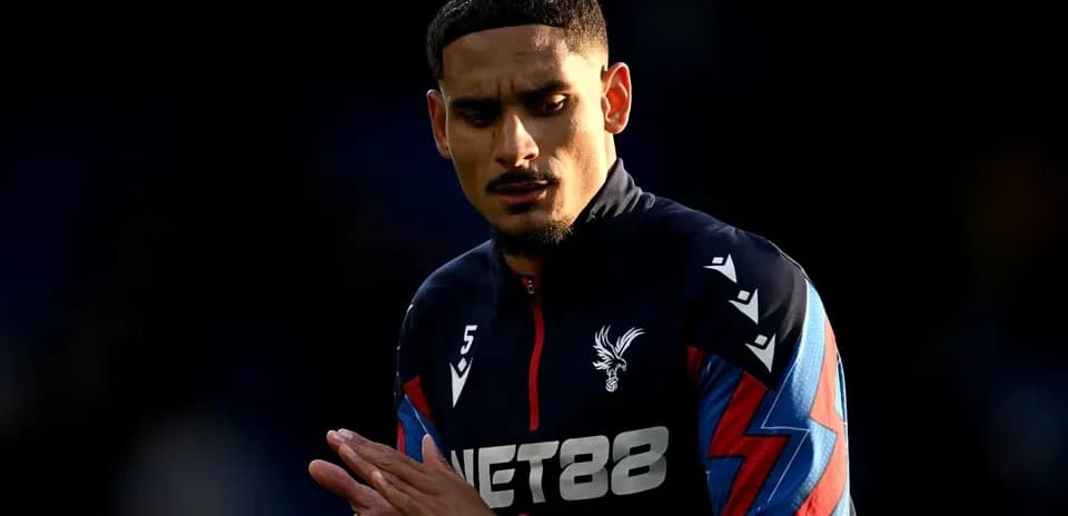 Player in Crystal Palace kit warming up on field