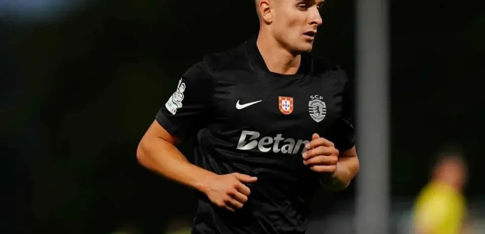 Player running on field in black kit