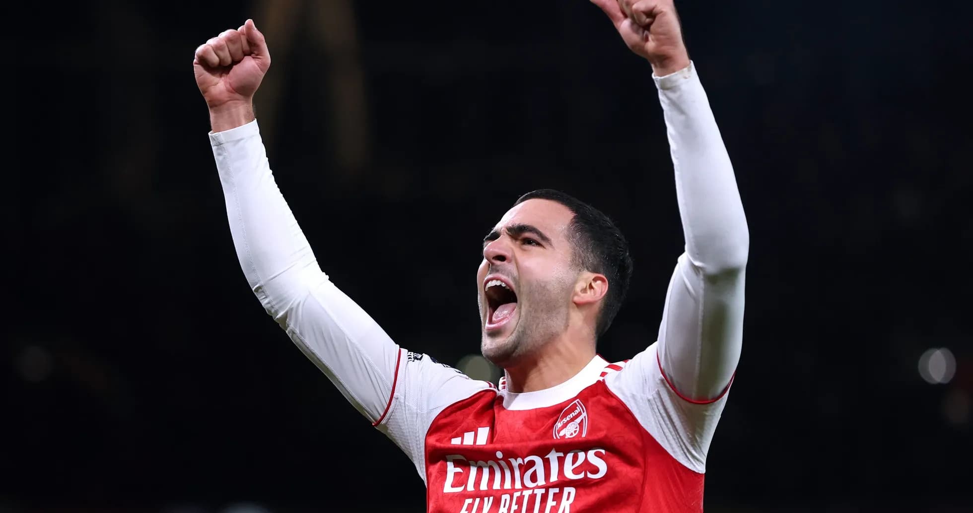 Player celebrating with raised fists in Arsenal jersey