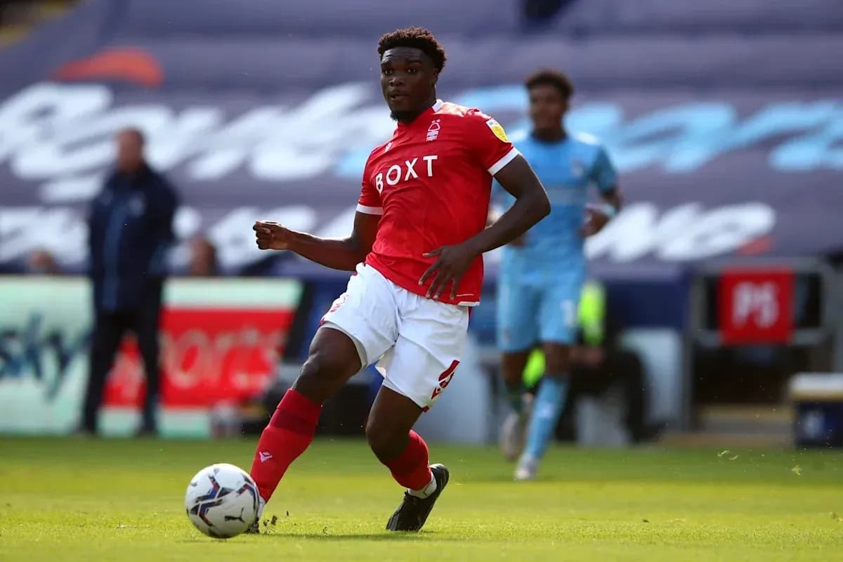 Player in red jersey dribbling the ball on field