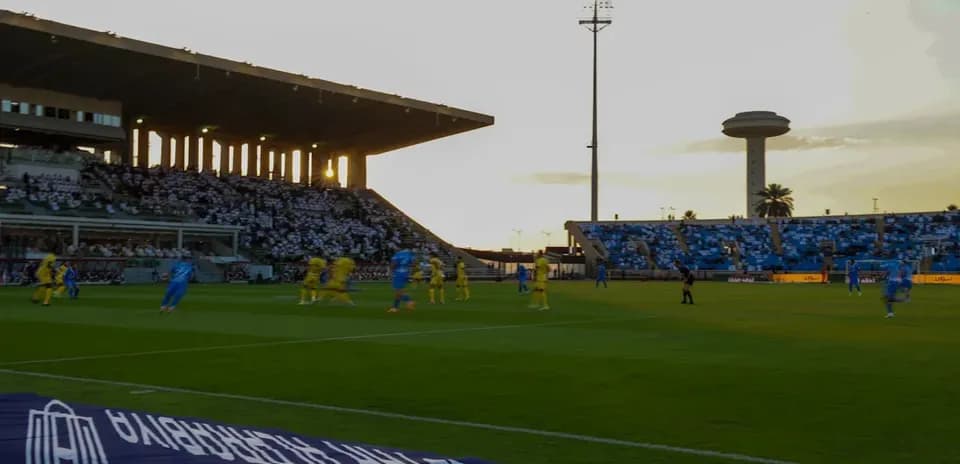 Players competing during a soccer match at sunset