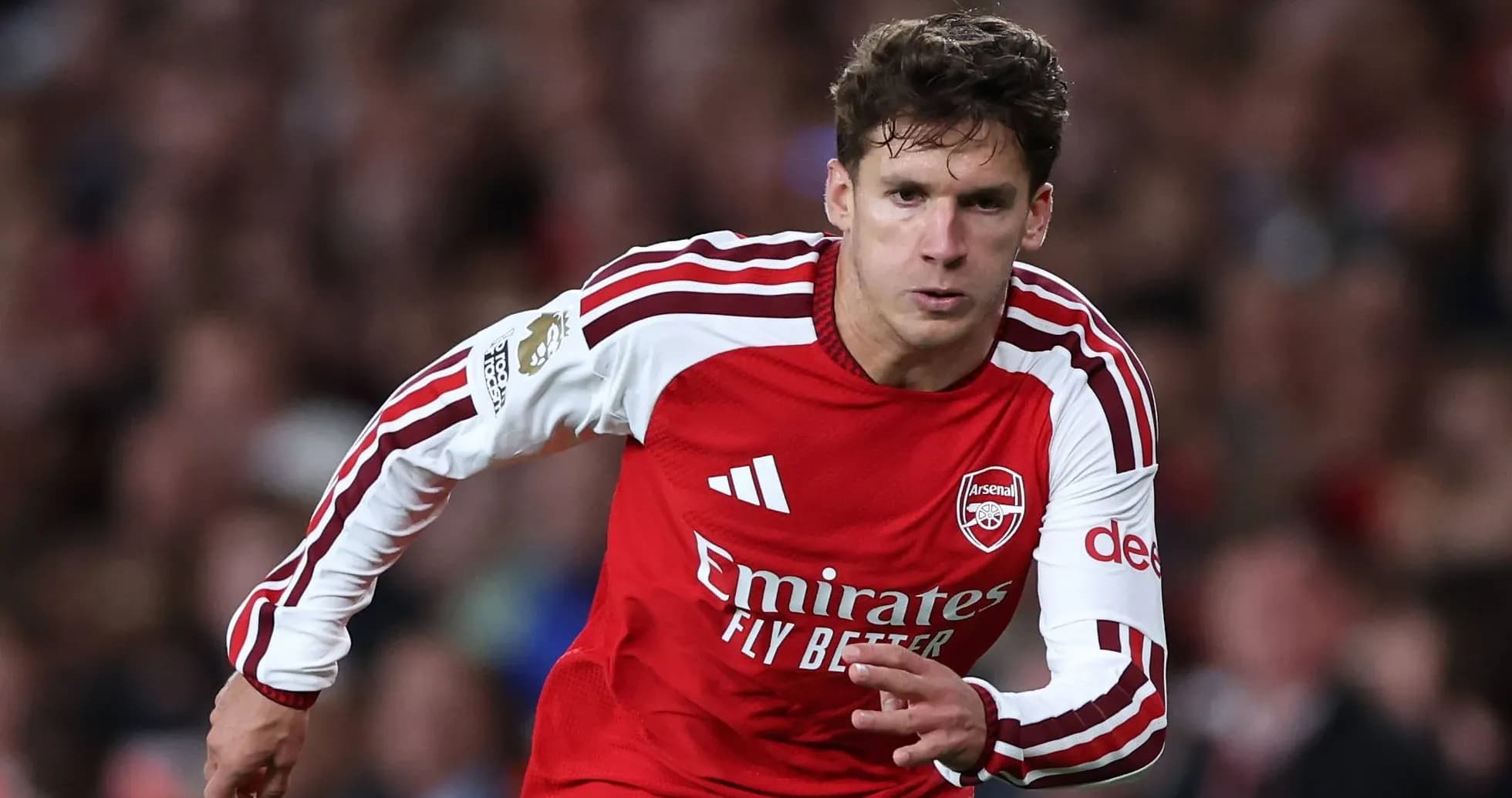 Player sprinting in Arsenal's red home kit