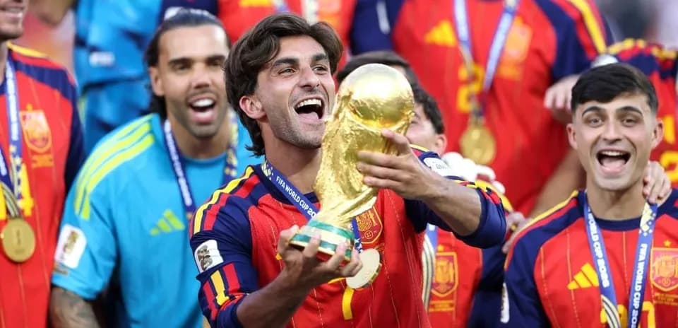 Player celebrating with FIFA World Cup trophy and teammates